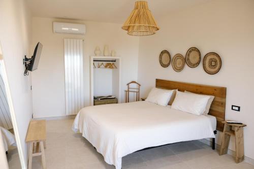 a bedroom with a white bed and clocks on the wall at B&B Il Belvedere 2 in Guardialfiera