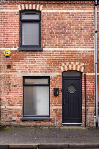a brick building with two windows and a door at Downshire Haven in Holywood
