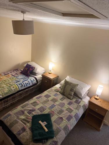 a room with two beds and two night stands with lamps at The Wright Place To stay in East Harling