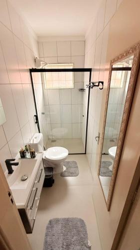 a bathroom with a sink and a toilet and a mirror at Sobrado de luxo em condomínio in Araçatuba