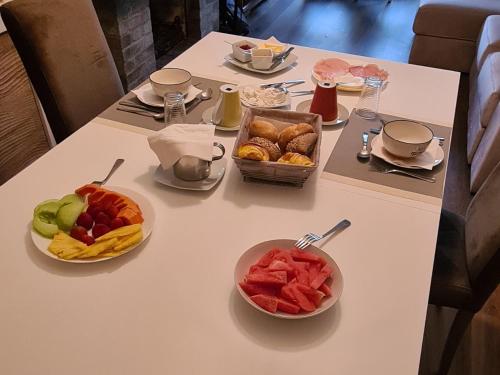 a table with plates of food and bowls of fruit at Mãe Maria House Guest House in Vila Chã
