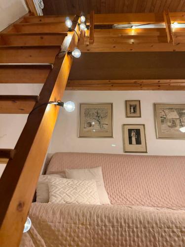 a bedroom with a bed and a wooden staircase at Romantický vejminek pod horami in Kounov