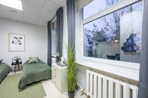 a room with a window and a bed and a plant at loond Stay- Kehra Ärimaja in Kekra