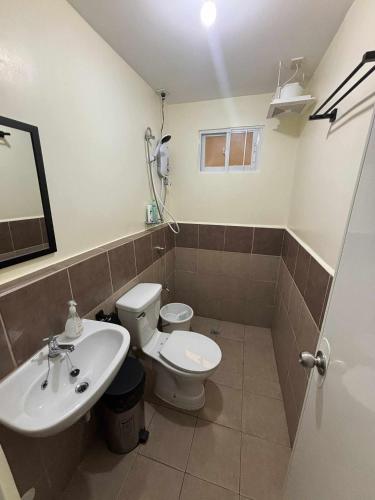 a bathroom with a white toilet and a sink at Arezzo Place Davao in Davao City