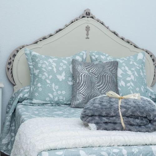 a bed with blue and white sheets and pillows at El Refugio de La Condesa Carmen in Manzanares
