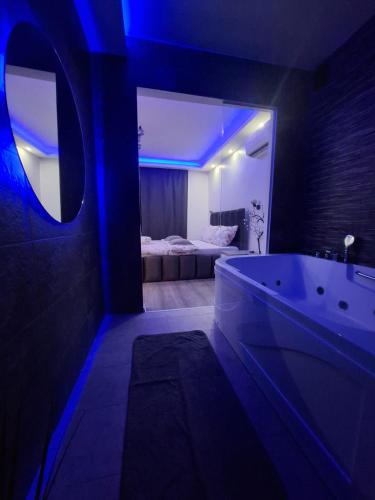 a bathroom with a tub and a bedroom with a bed at Stars lux room in Belgrade