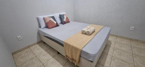 a bed with two towels on it in a room at Apartamento central completo in Tangara da Serra