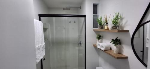 a shower with a glass door in a bathroom at RN Studio Apê 506 in Maceió