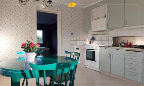 a kitchen with a green table and chairs in a kitchen at Woxy Prilutta in Voxnabruk
