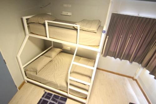 a small room with two bunk beds in it at The Moon Hostel Huahin in Hua Hin
