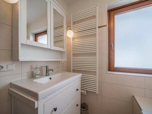 a white bathroom with a sink and a window at Hohe Tauern in Mittersill