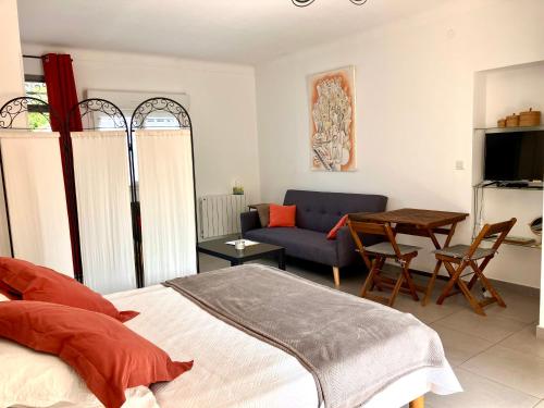 a bedroom with a bed and a couch and a table at Studio Mas Pierre in Maureillas