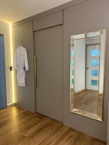 a dressing room with a door and a mirror at Hotel Maysa Caruaru in Caruaru