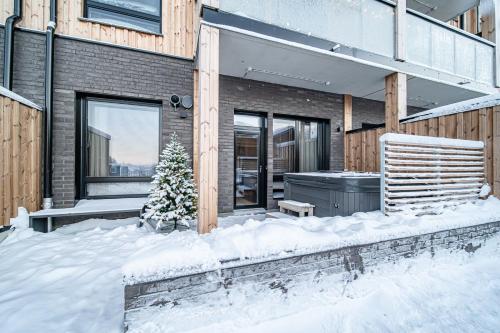 a house with a christmas tree in the snow at Le Chalet Lingonberry D3 Ski-in Ski-out, Hot Tub by Aavalevi in Levi