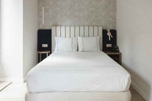 a bedroom with a large bed with white sheets and pillows at M'AR De AR Auria in Lisbon