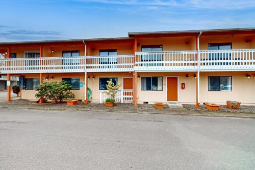 an orange and white building with plants in front of it at Sea Treasures Inn #101 in Rockaway Beach