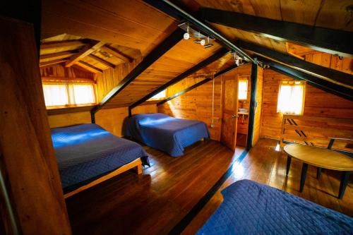 een kamer met twee bedden in een houten hut bij Tombstone in Valle de Bravo