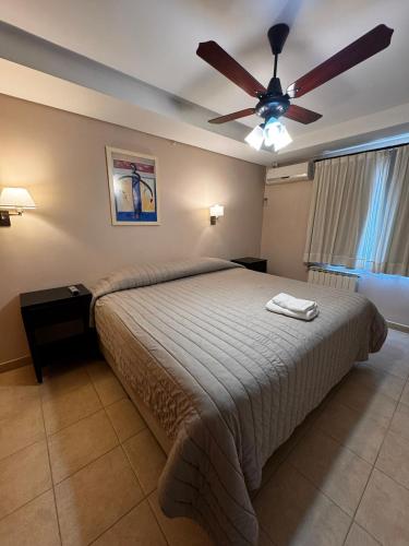 a bedroom with a bed and a ceiling fan at Patagonia Hotel in Caleta Olivia
