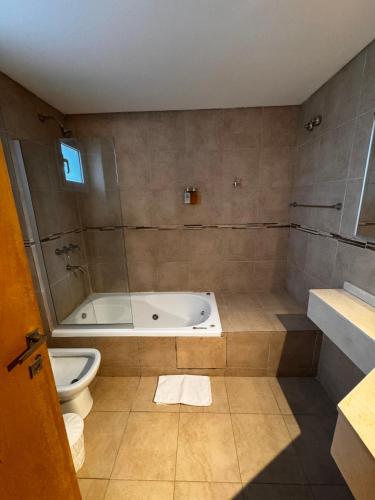 a bathroom with a tub and a toilet at Patagonia Hotel in Caleta Olivia