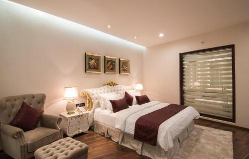 a bedroom with a bed and a couch and a chair at Park Regis Goa in Arpora