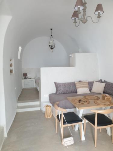 a living room with a table and a couch at Kalypso Tholos in Astypalaia