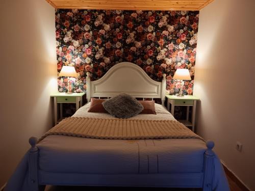 a bedroom with a large bed with a floral wallpaper at O Cantinho de Góis in Góis