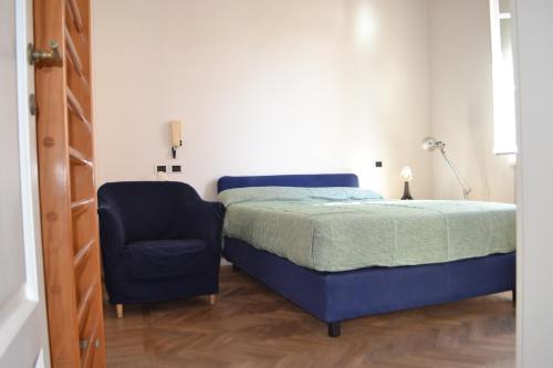 a bedroom with a bed and a blue chair at La Liberty in Marciana Marina