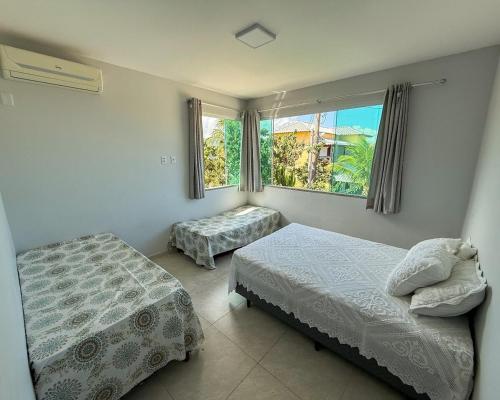 a bedroom with two beds and a window at House in Jaconé in Maricá