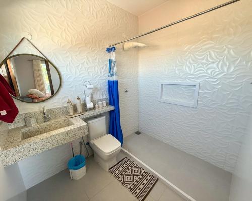 a bathroom with a sink and a toilet and a mirror at House in Jaconé in Maricá