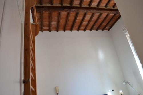a room with a white wall and a wooden ceiling at La Liberty in Marciana Marina