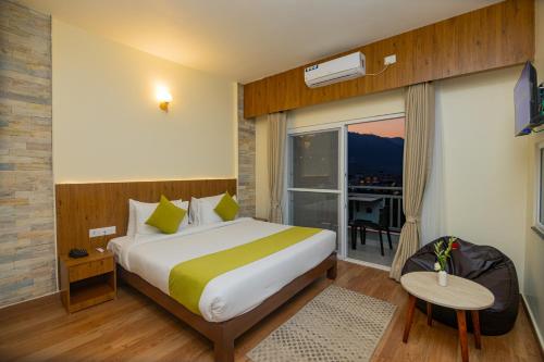 ein Hotelzimmer mit einem Bett und einem großen Fenster in der Unterkunft Hotel Dashain in Pokhara