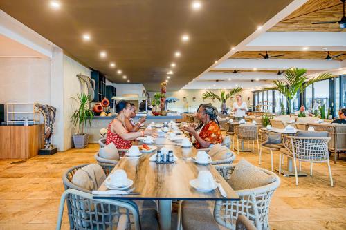 two women sitting at a table in a restaurant at Kombo Beach Resort in Serekunda