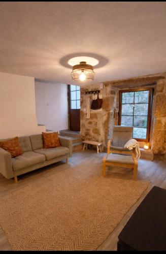a living room with a couch and a chair at Casa Martinho & Neves in Seia