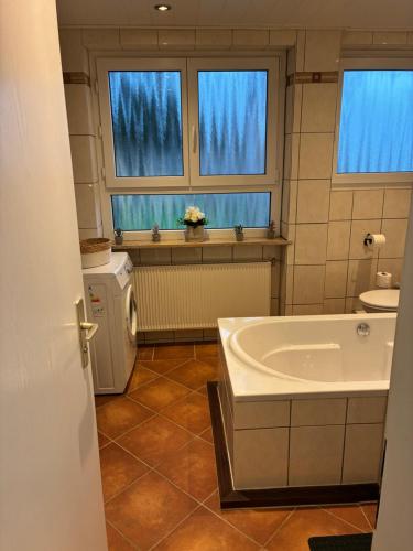 ein Badezimmer mit Badewanne, Waschbecken und zwei Fenstern in der Unterkunft ChrisTho - Am Rheinsteig in Vallendar