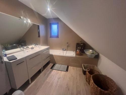 a attic bathroom with a sink and a tub and a sink at Escapade Romantique, Salon cathédrale, Strasbourg in Schiltigheim