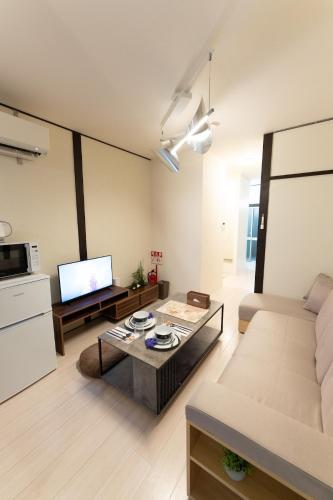 a living room with a couch and a coffee table at なんばや心斎橋にも直結の最大8名宿泊可能の広々メゾネット JPtrad 桔梗 in Osaka