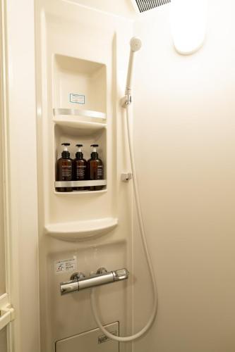 a refrigerator withalcohol bottles in it in a bathroom at なんばや心斎橋にも直結の最大8名宿泊可能の広々メゾネット JPtrad 桔梗 in Osaka