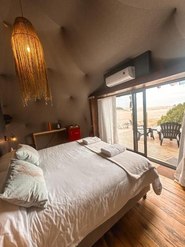 a bedroom with a large bed and a large window at Domos Park in Mar de las Pampas
