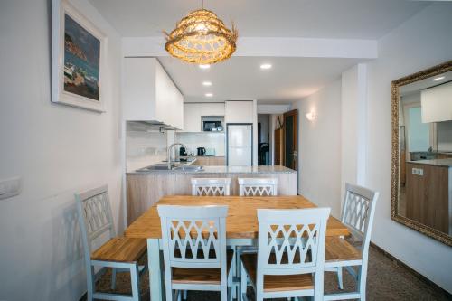 a kitchen and dining room with a wooden table and chairs at Apartamento Floral al centro de Palamós con Wi-Fi in Palamós