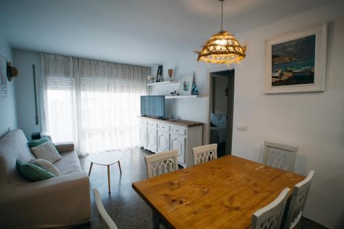 a kitchen and dining room with a table and a couch at Apartamento Floral al centro de Palamós con Wi-Fi in Palamós