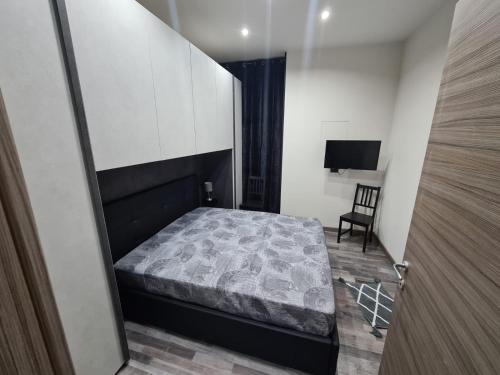 a bedroom with a bed and a chair at L'Angolo Felice in Riposto