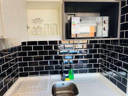 a kitchen with black and white tile on the wall at Muelle Barón - Terminal de Buses in Valparaíso