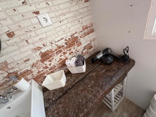 a bathroom with a counter with a sink and a brick wall at Casa Rebeca in Torre de Benagalbón