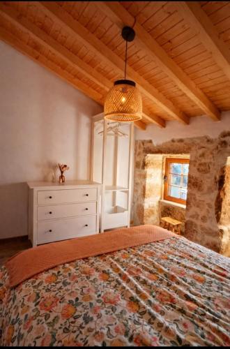 a bedroom with a bed with a dresser and a window at Casa Martinho & Neves in Seia
