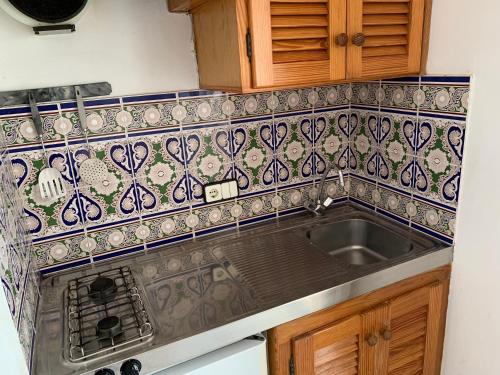 a kitchen with a sink and a tile back splash at Apartamentos, Edificio Pujolets Es Pujols-Playa in Es Pujols