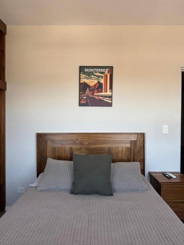 a bedroom with a bed with a picture on the wall at Espectacular depa en el Barrio in Monterrey