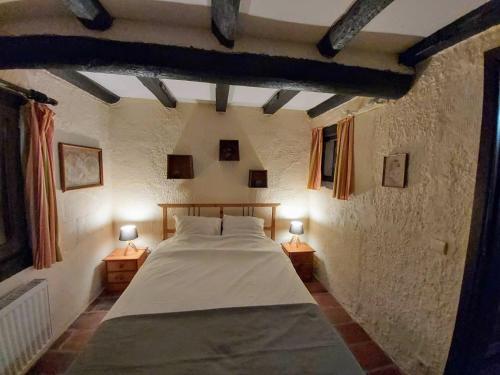 a bedroom with a large bed with two lamps at La Bergerie in Froid-Chapelle