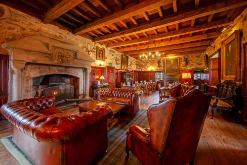 a living room with leather furniture and a fireplace at Barcaldine Castle in Oban