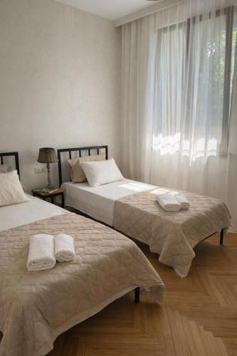 two beds sitting next to each other in a bedroom at Sweet Home Tskaltubo Family Guesthouse Near Spa Park in Tsqaltubo