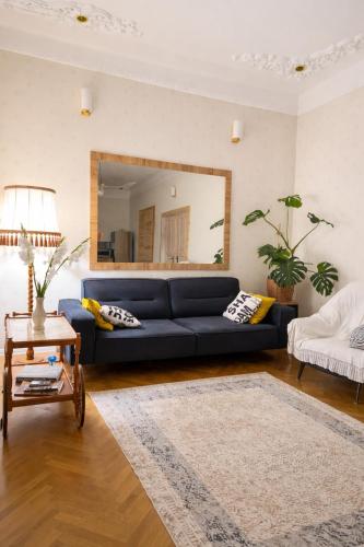 a living room with a blue couch and a mirror at Sweet Home Tskaltubo Family Guesthouse Near Spa Park in Tsqaltubo
